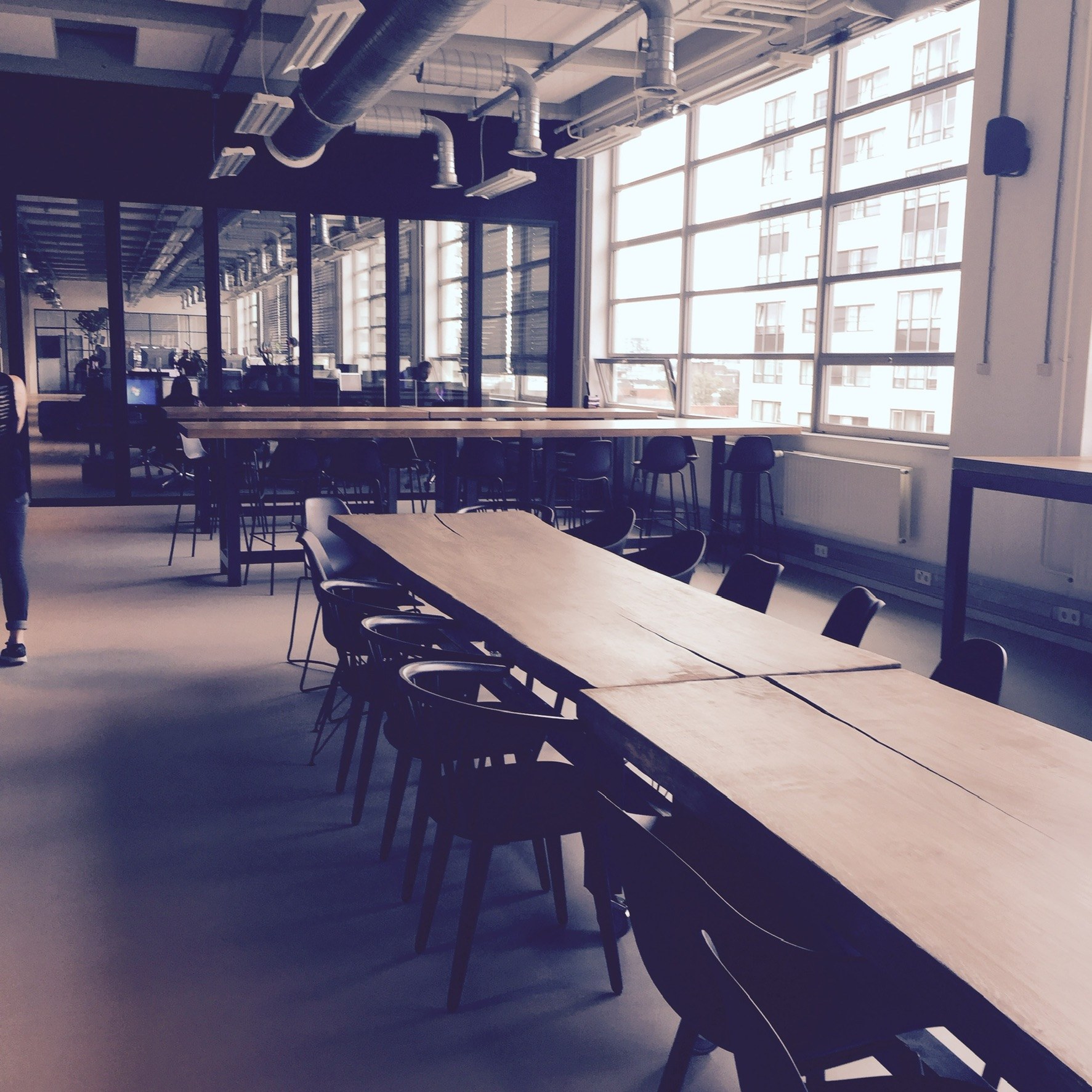 Lange tafels en zitplekken in een industrieel interieur